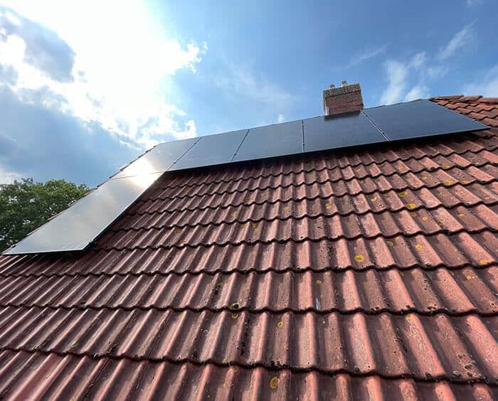 Zonnepanelen op schuin dak met zonnige lucht