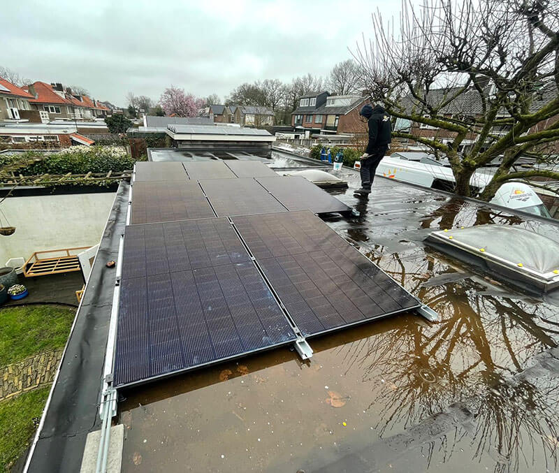 Zonne-energie installatie op plat dak met installateur